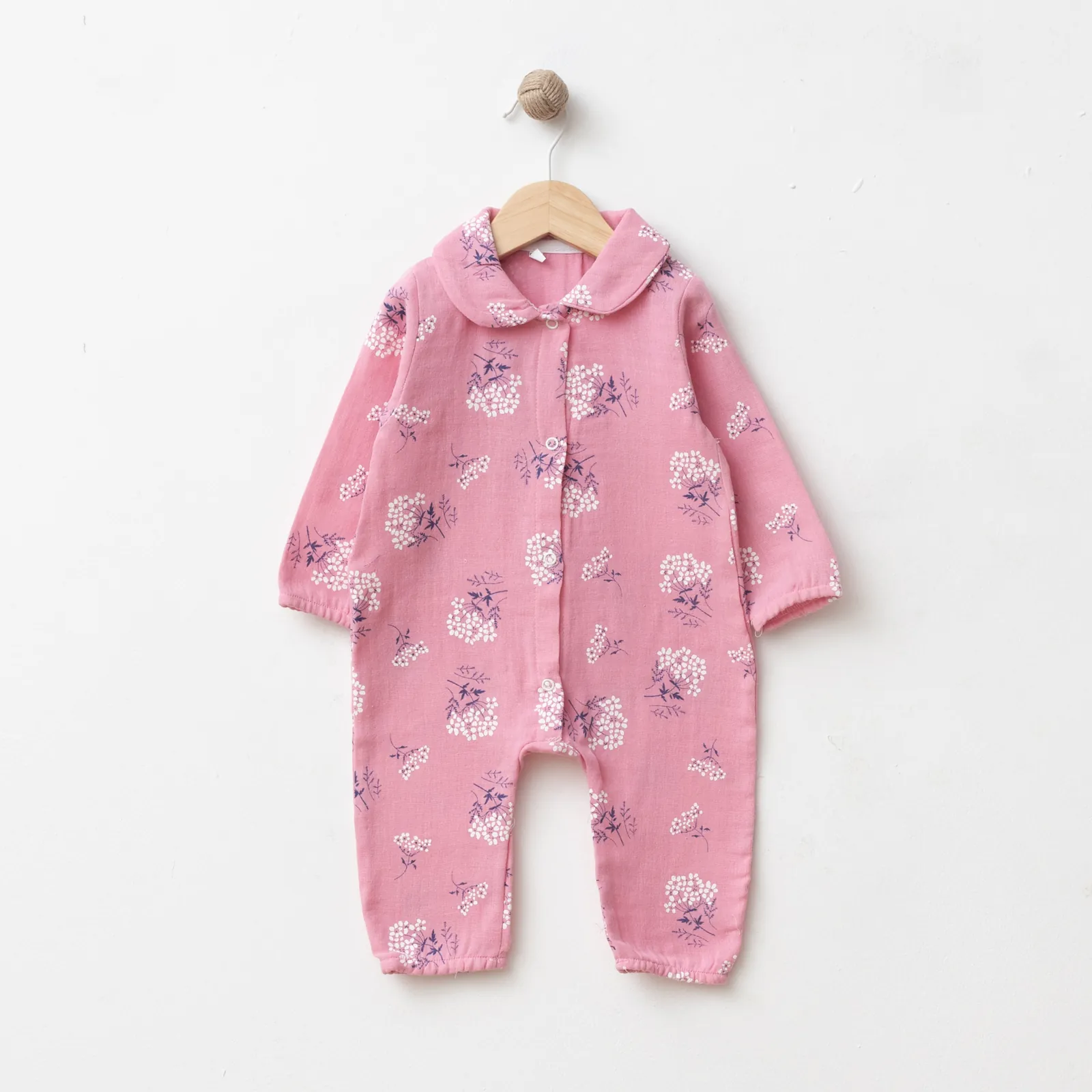 Wholesale GOTS-certified 100% cotton floral baby girl romper with rounded collar and front snap buttons, available in 3 to 12 months