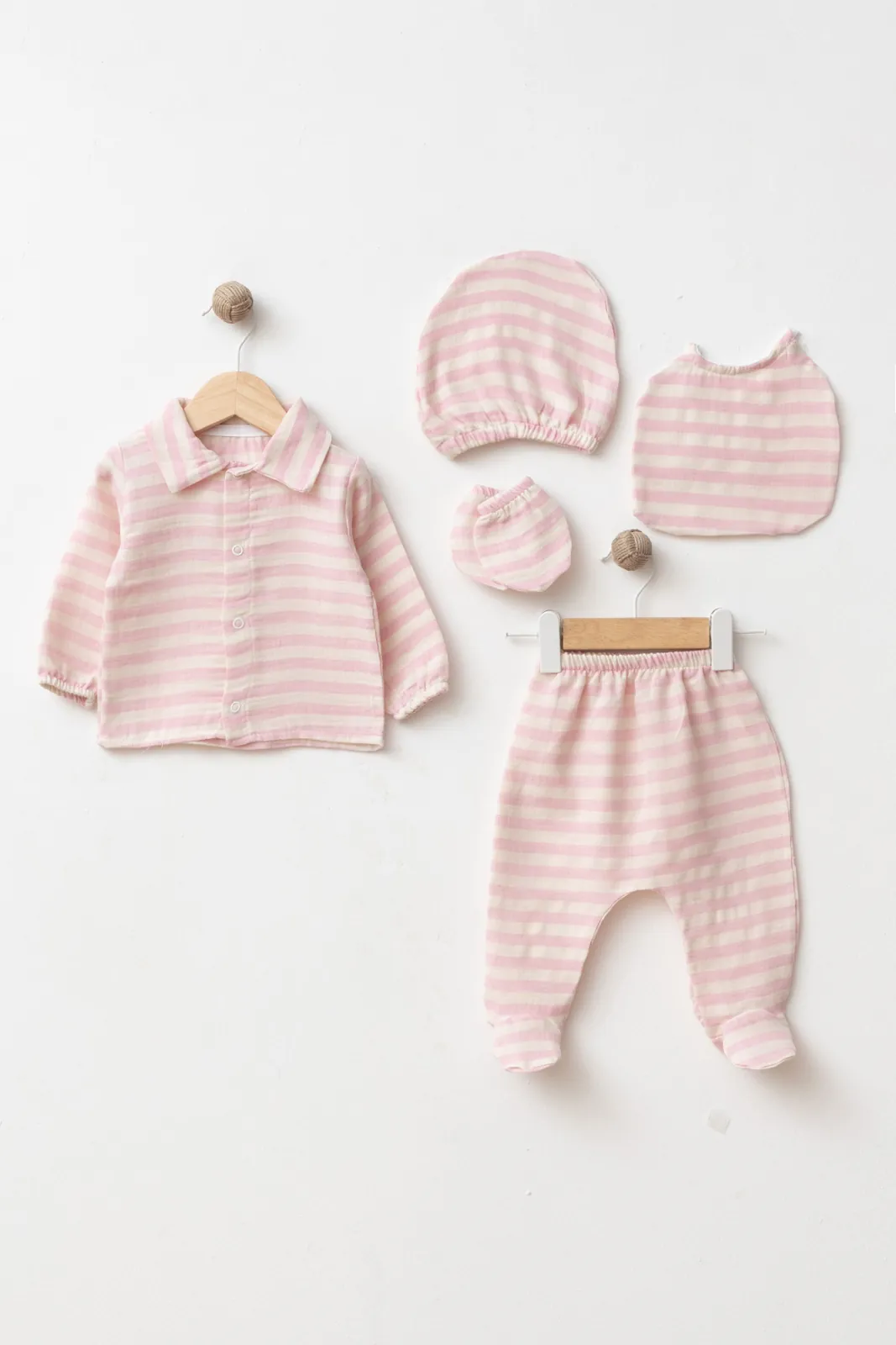 Wholesale 5-piece GOTS-certified cotton newborn baby girl hospital set with button-front top, footed trousers, matching hat, bib and mittens.